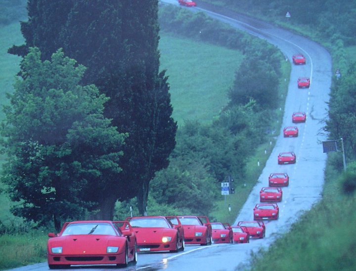  vintageesque photo of 15 Ferrari F40s being lovingly navigated down a 